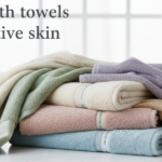Best bath towels for sensitive skin laid flat on bathroom counter — soft white Turkish cotton, microfiber waffle weave, and bamboo washcloths reviewed for eczema and rosacea
